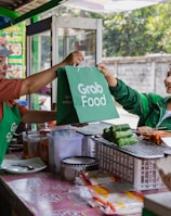 a woman handing a green bag to another woman