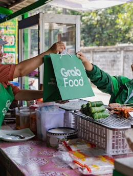 a woman handing a green bag to another woman