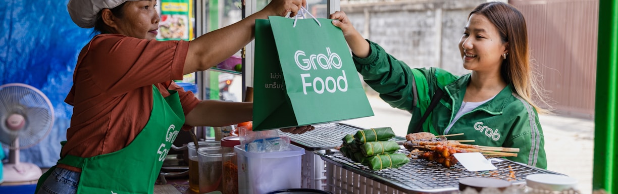 a woman handing a green bag to another woman
