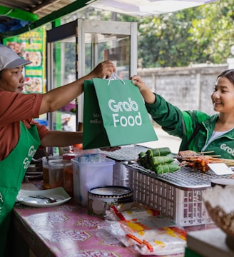 a woman handing a green bag to another woman