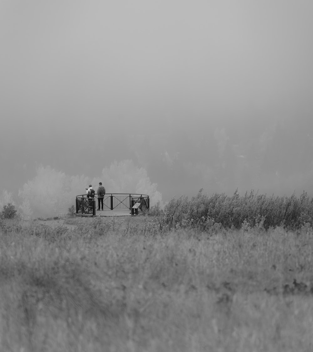 a couple of men standing on top of a dirt road