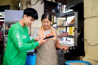 A cheerful adult child showing a simple kitchen gadget to their parent.