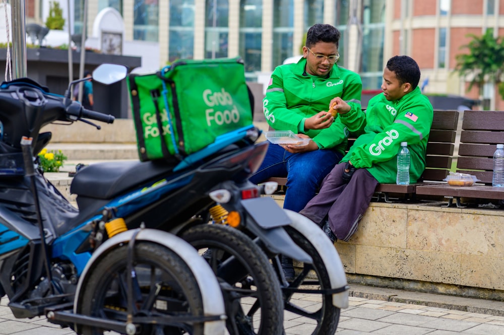 a man sitting on a bench next to a young boy