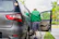 A friendly driver helping a passenger into a clean, accessible transport vehicle outside a hospital entrance.