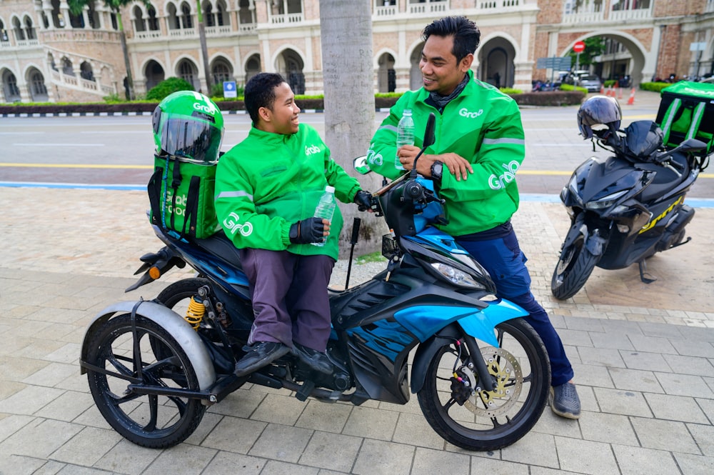 two men in green jackets on a scooter