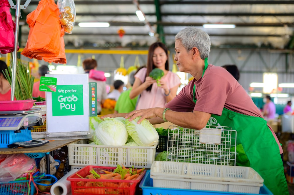 a man standing in front of a table filled with vegetables