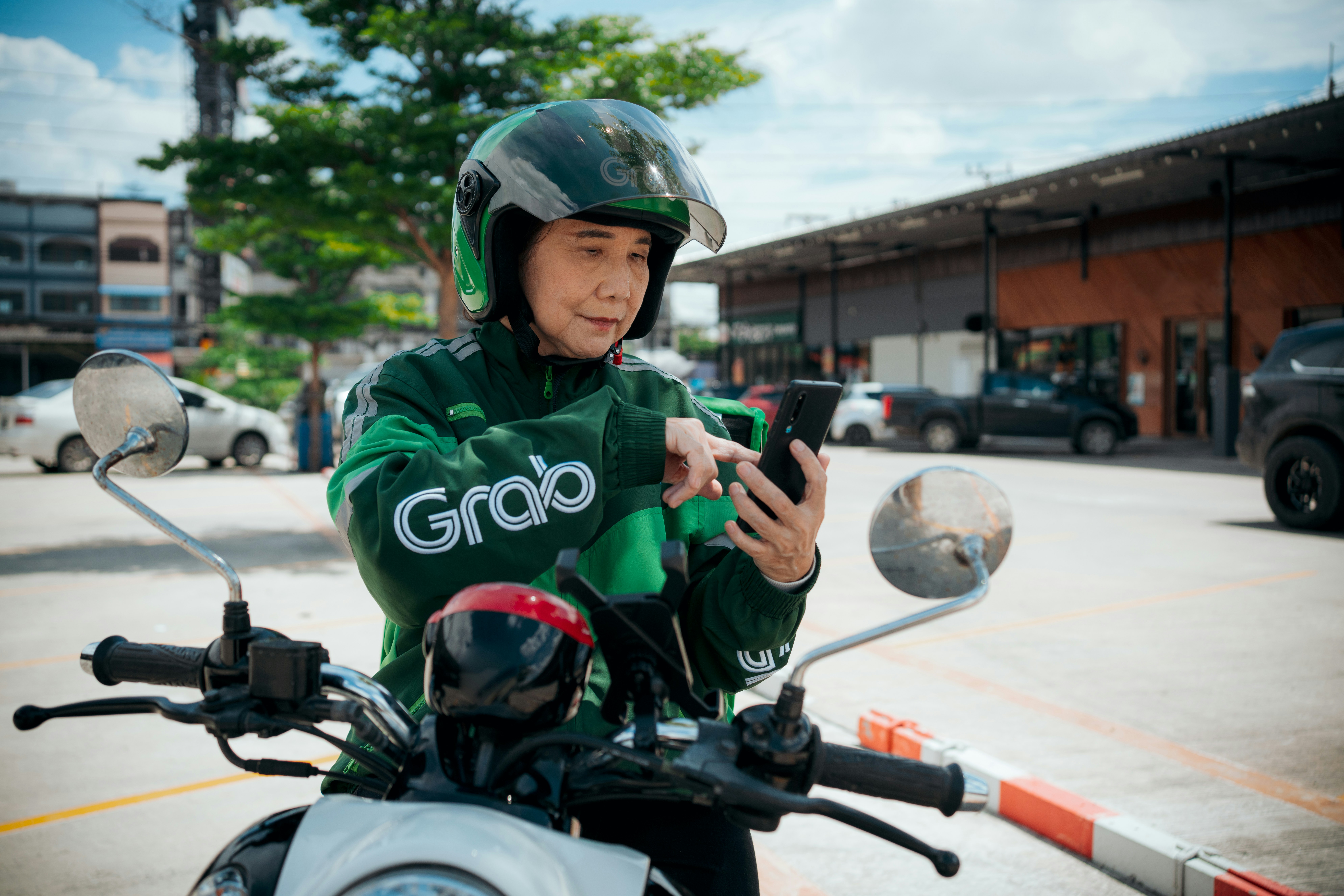 a man in a green jacket on a motorcycle