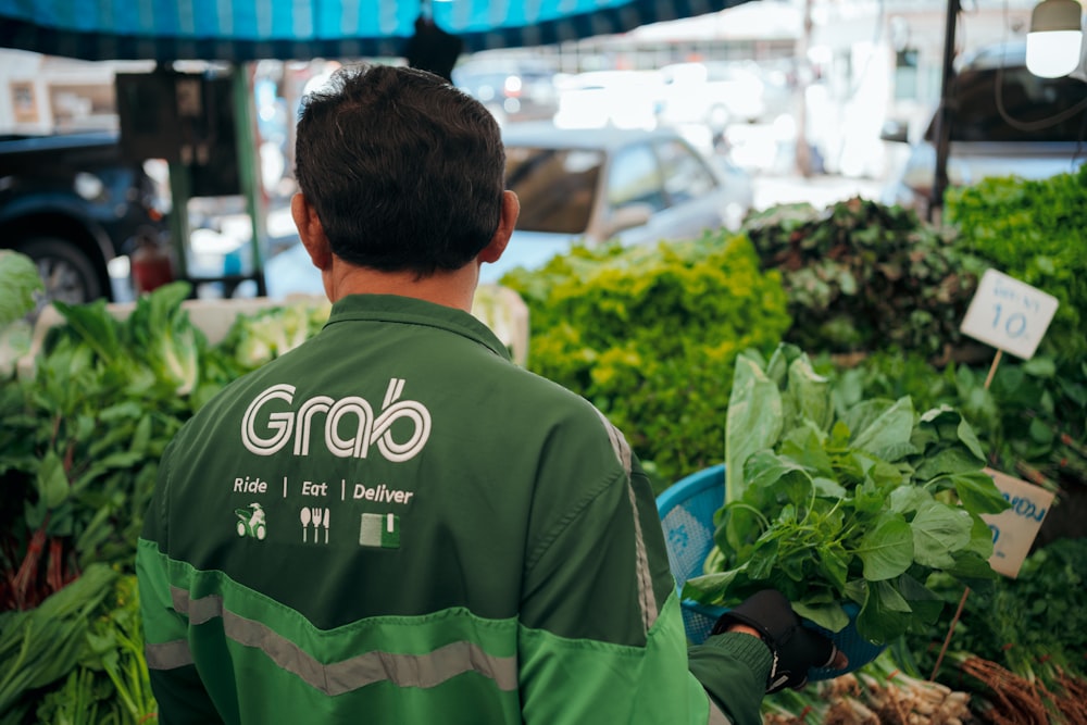 a man standing in front of a bunch of vegetables