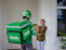 Smiling woman holding a package from nx shopping at her doorstep.