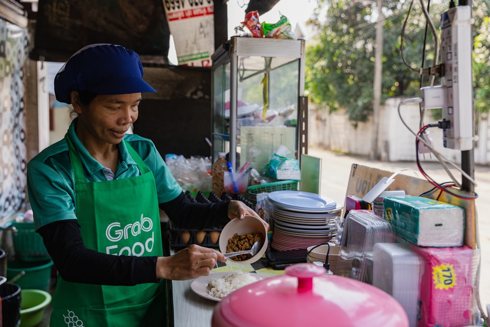 a woman in a green apron preparing food