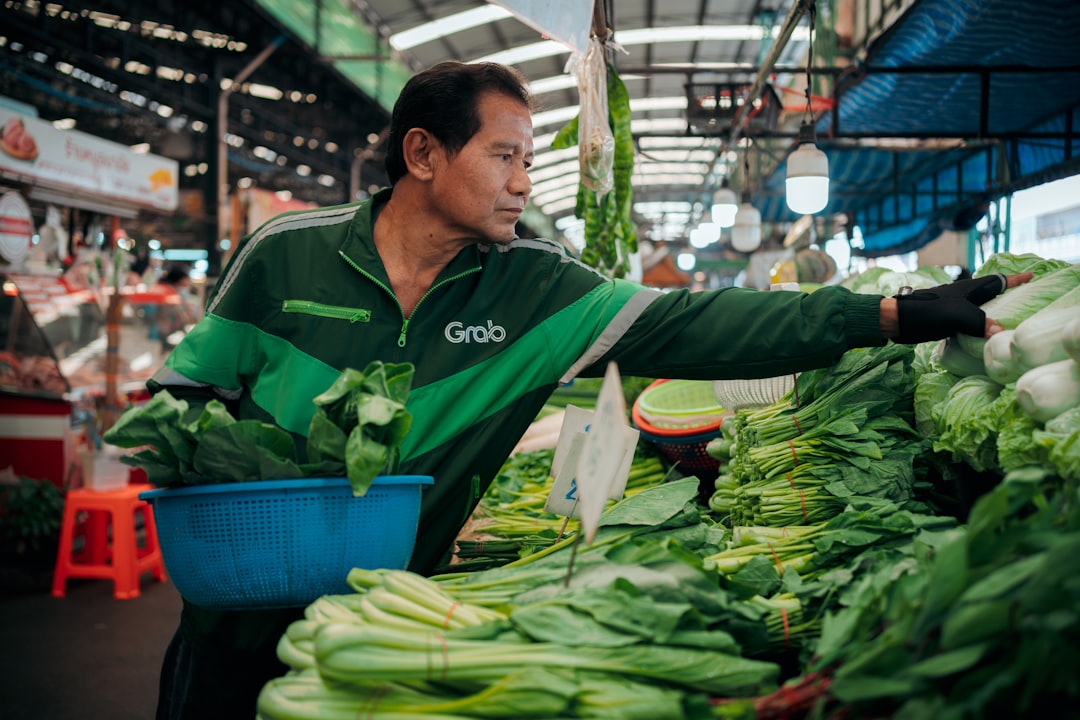a man standing in front of a display of vegetables,
