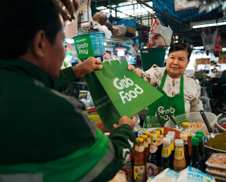 a woman holding up a green sign in front of a man