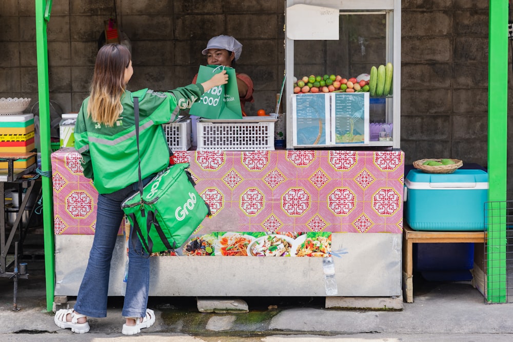 a man and a woman standing at a fruit stand