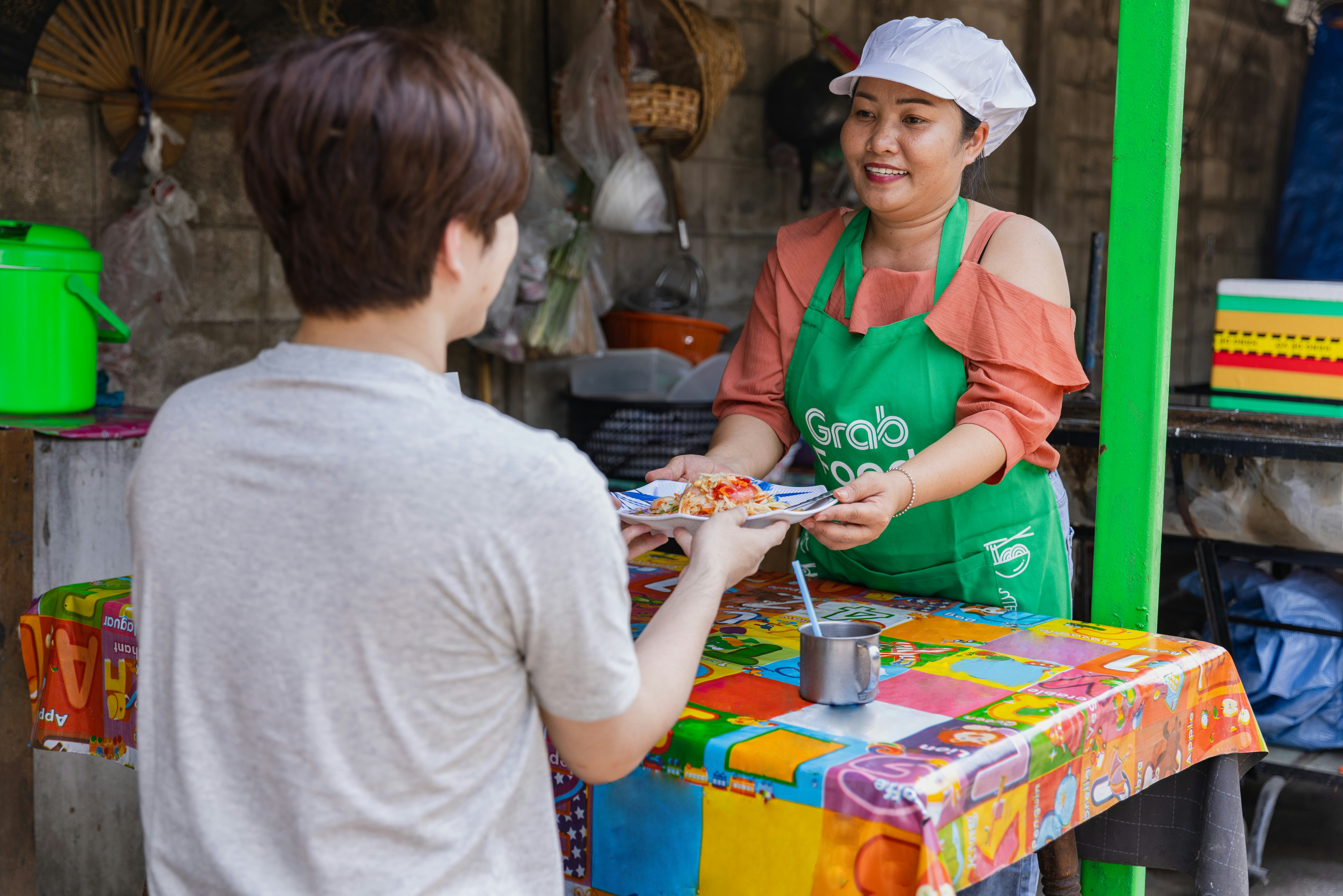 a woman in an apron serving food to a man