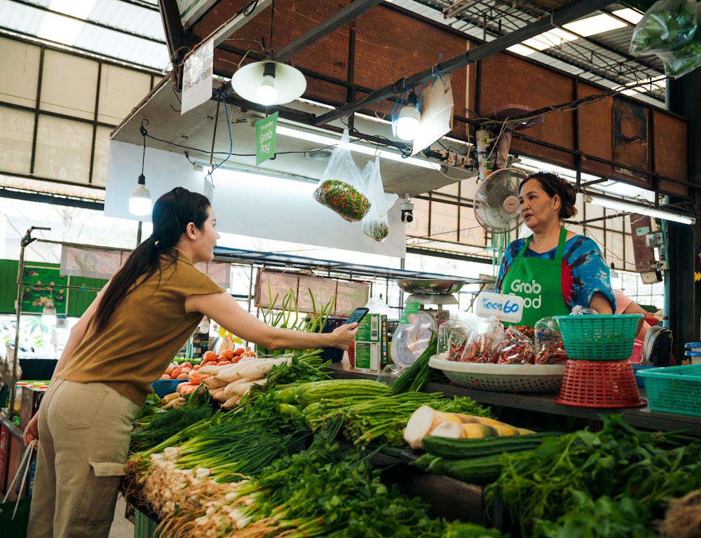 a woman standing in front of a table filled with vegetables