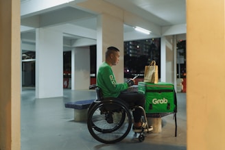 a man in a green shirt sitting in a wheel chair