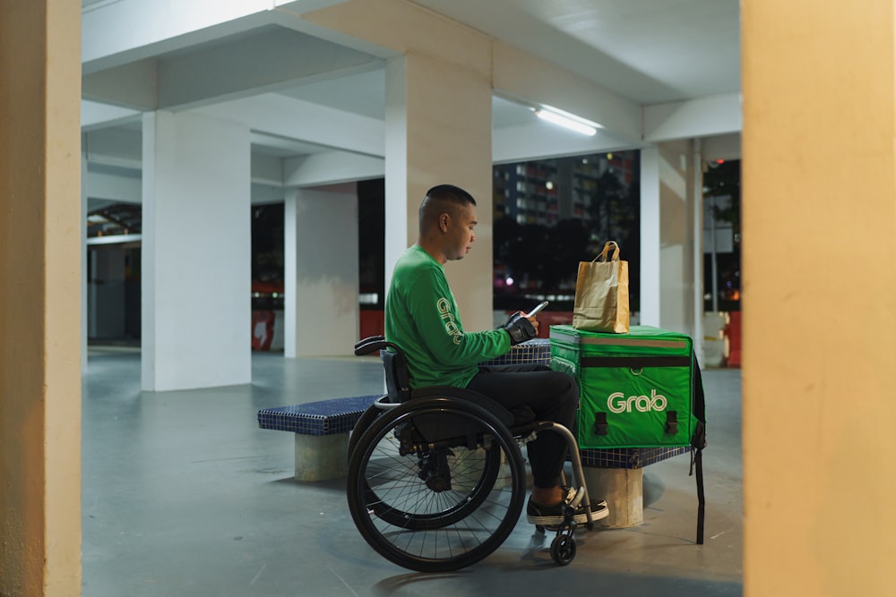 a man in a green shirt sitting in a wheel chair