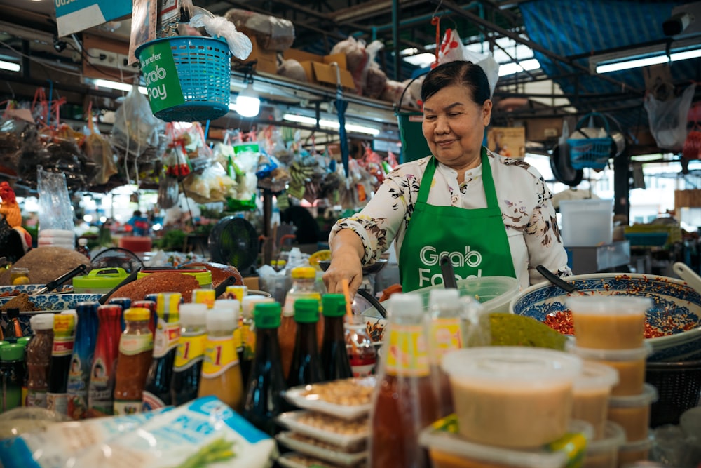 a woman in an apron preparing food at a market