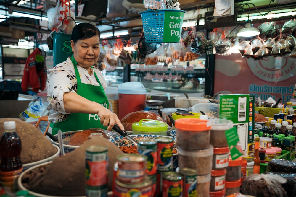 a woman in a green apron cooking in a kitchen