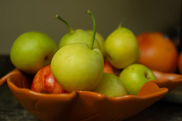 A sleek ceramic fruit bowl with layered design on a wooden table.