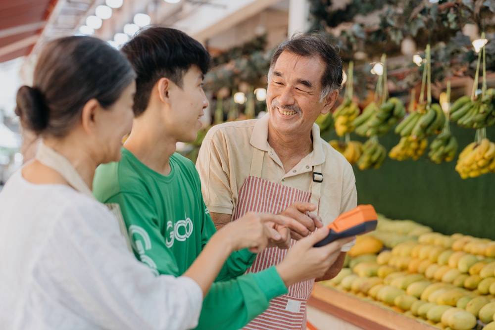 um casal de pessoas em frente a uma banca de frutas