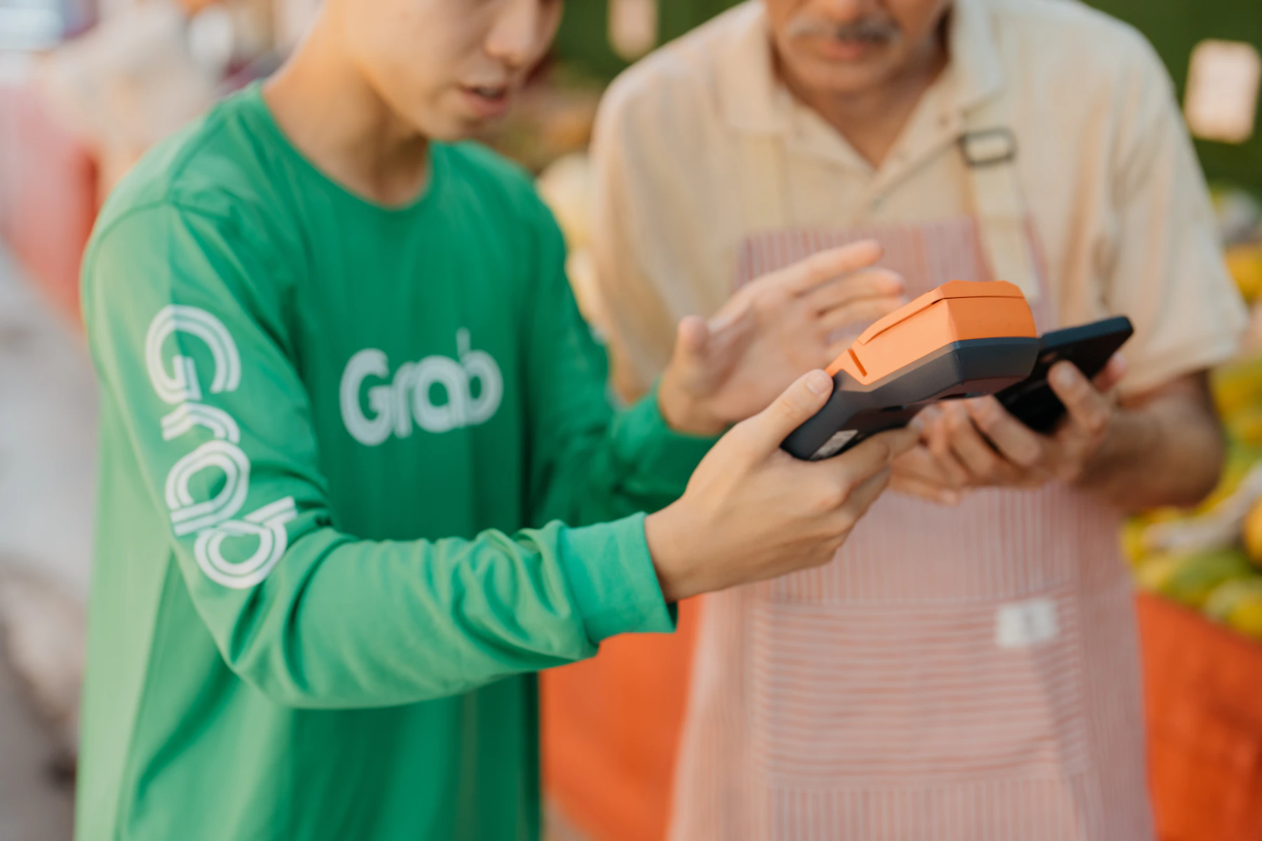 A customer using a mobile device at a Southeast Asian market