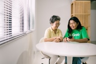 Smiling woman consulting with a friendly doctor in a bright clinic room.