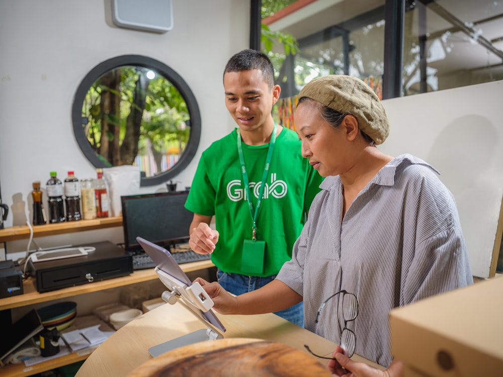 a man and a woman looking at a piece of wood