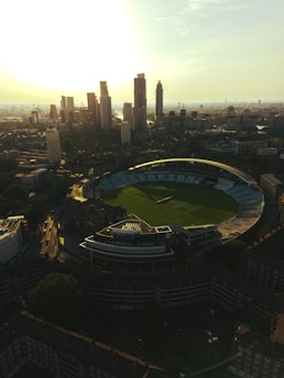 Sunrise over a city skyline with Stuart Broad speaking into a microphone in a cozy studio.