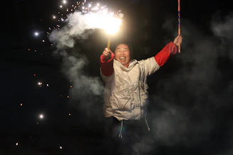 Close-up of a happy customer holding a box of fireworks with a bright smile.