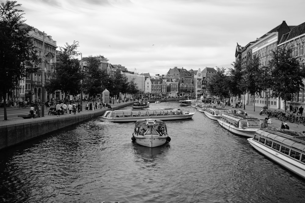 a black and white photo of boats on a river