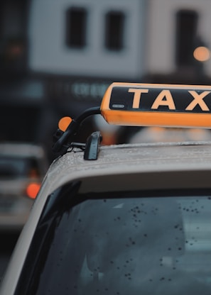 A close-up of the تاكسي عاجــل 24 logo on a taxi.