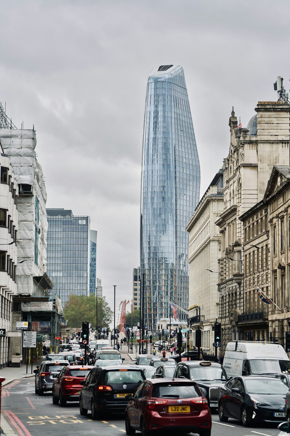 a city street filled with lots of traffic next to tall buildings