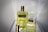 Two bottles of Aramis fragrance are displayed on a reflective surface. The larger bottle on the left contains a yellow liquid and has a golden cap, while the smaller bottle on the right is partially open. Both bottles feature the Aramis label prominently.