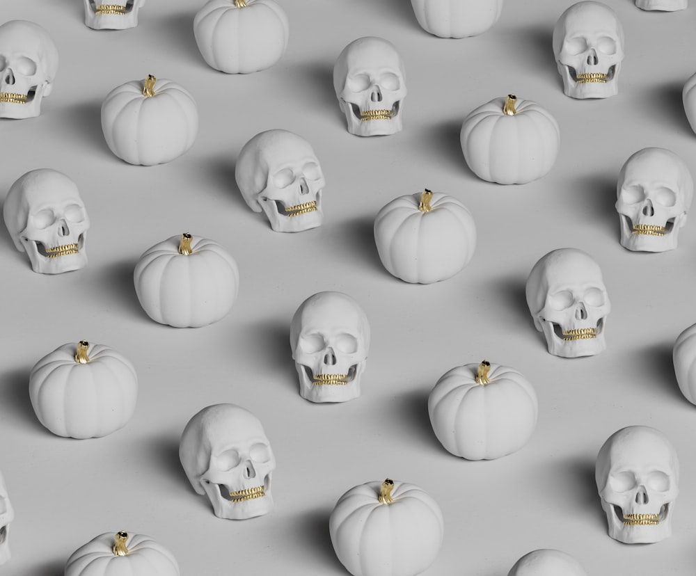 a group of white pumpkins with skulls on them