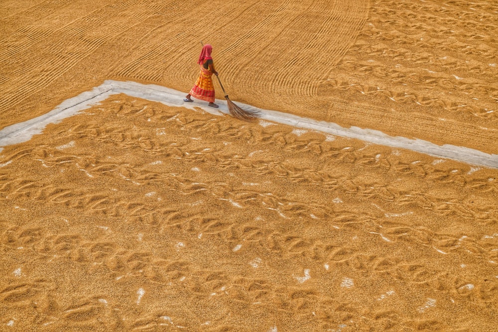 a woman in a red dress is walking through a field