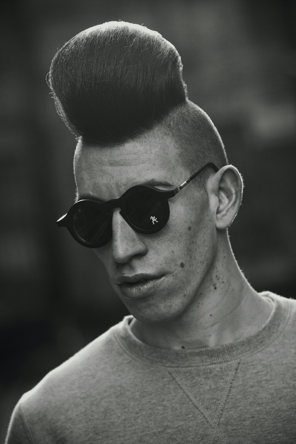 a man with a mohawk undercut and sunglasses