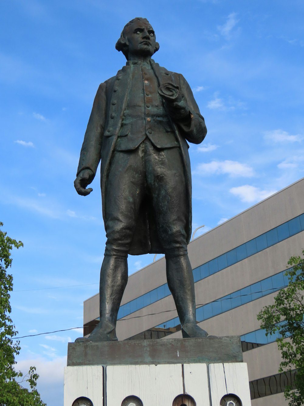 a statue of a man standing in front of a building