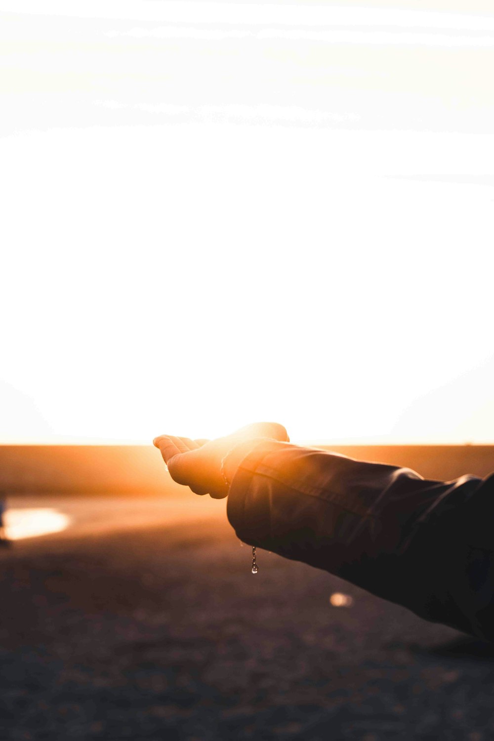 a person holding their hand out to the sun