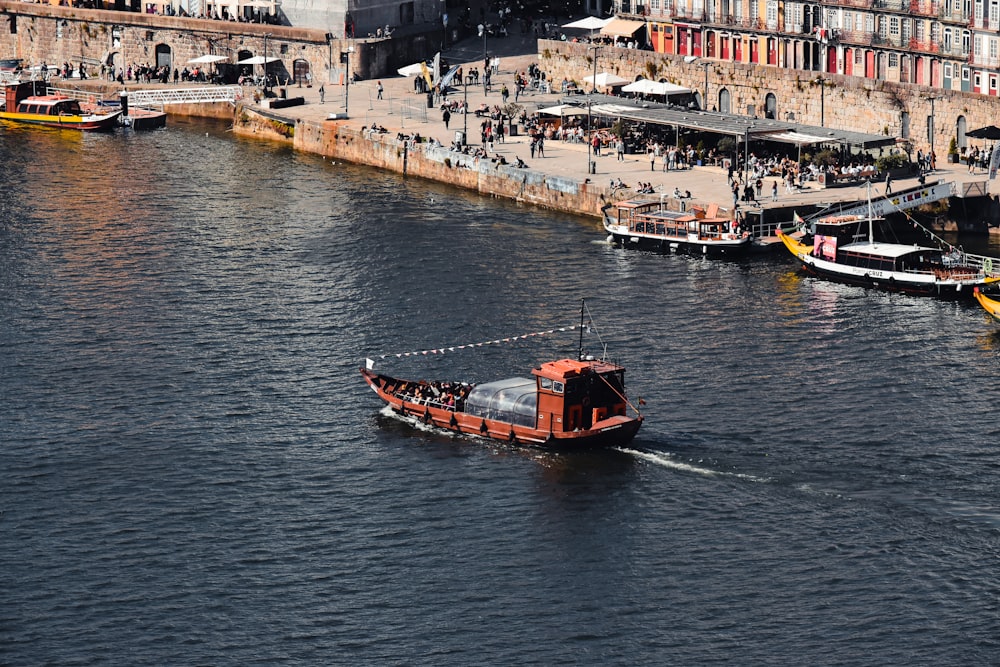 a small boat traveling down a river next to a city