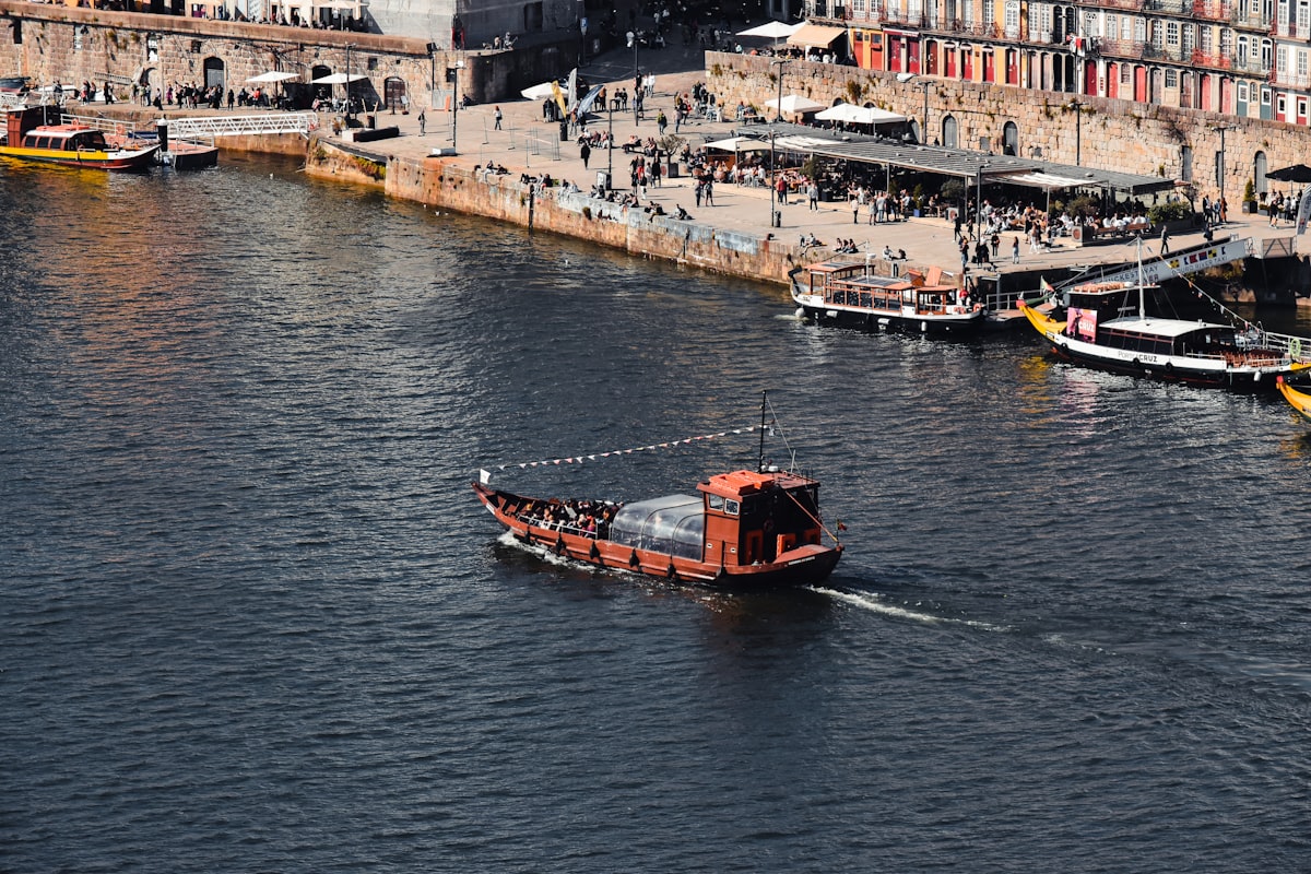 Porto April — a small boat travelling the Douro River past the city waterfront in spring light
