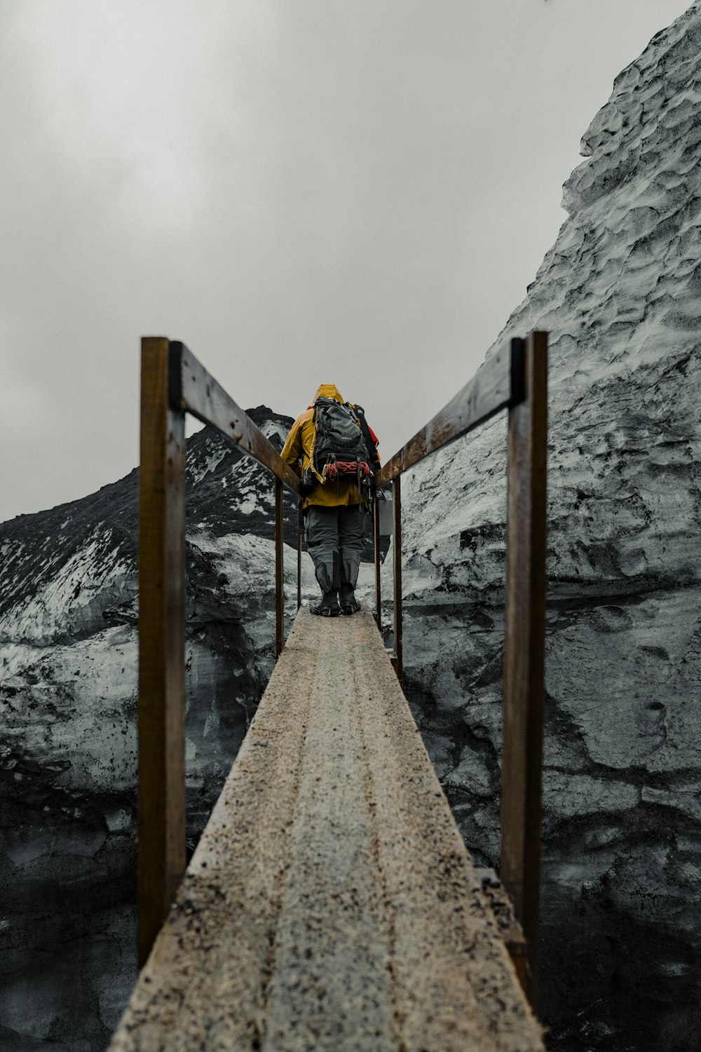 ein mann mit einem rucksack, der über eine brücke geht