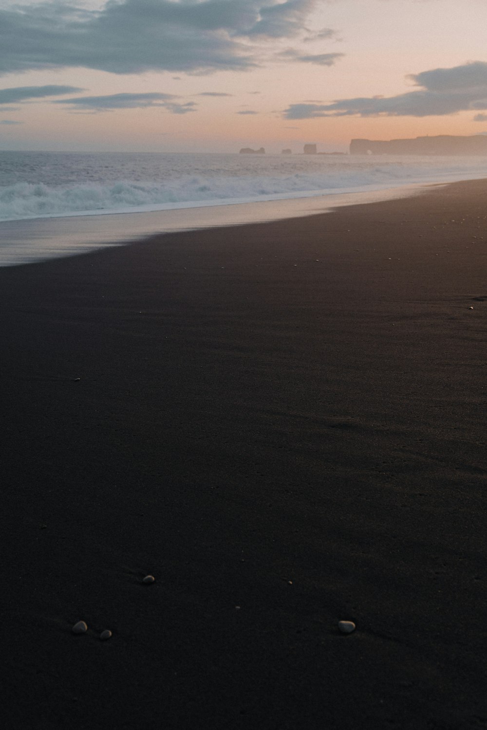 a person walking on a beach with a surfboard