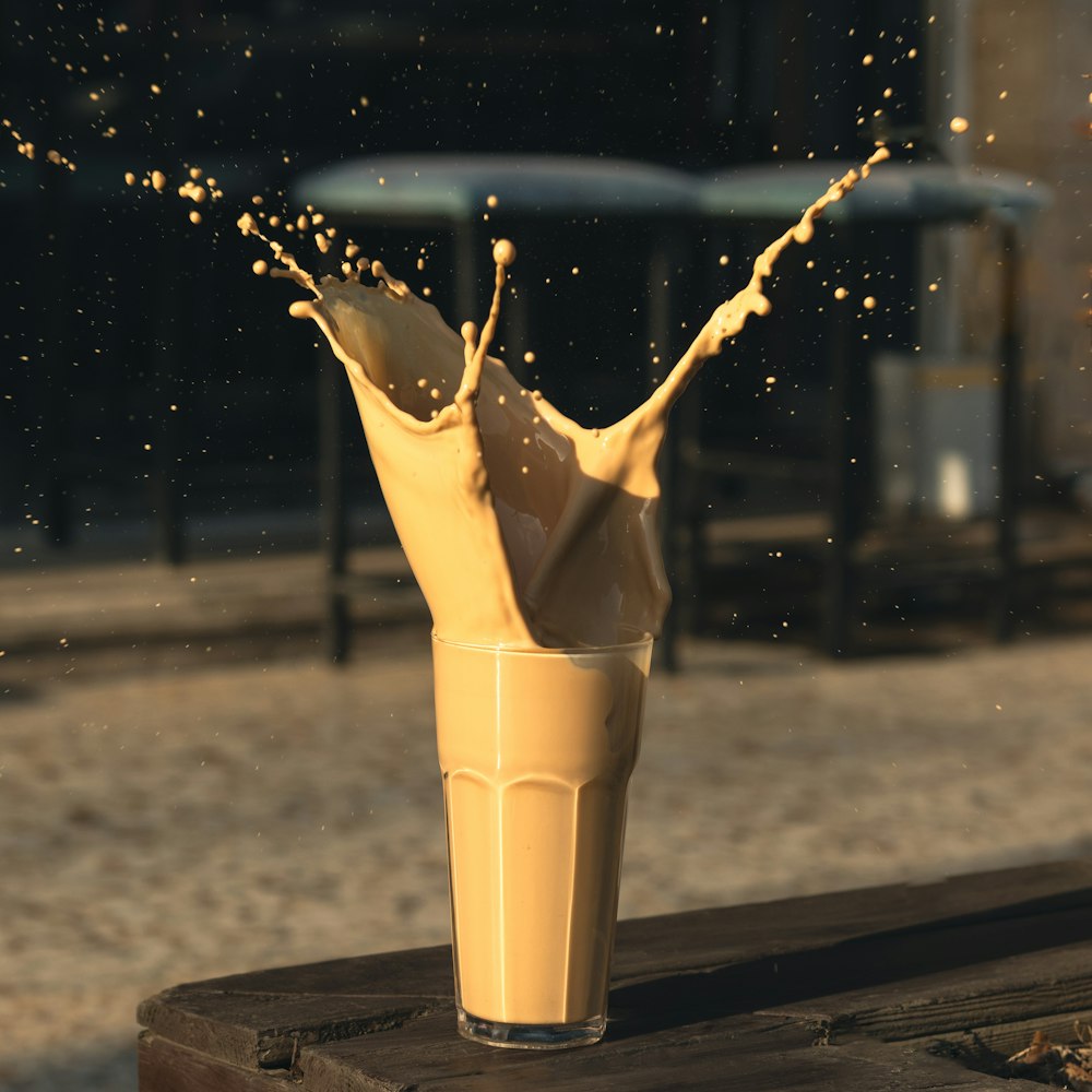 a glass filled with liquid on top of a wooden table