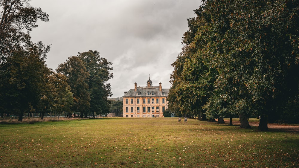 a large building sitting in the middle of a lush green field