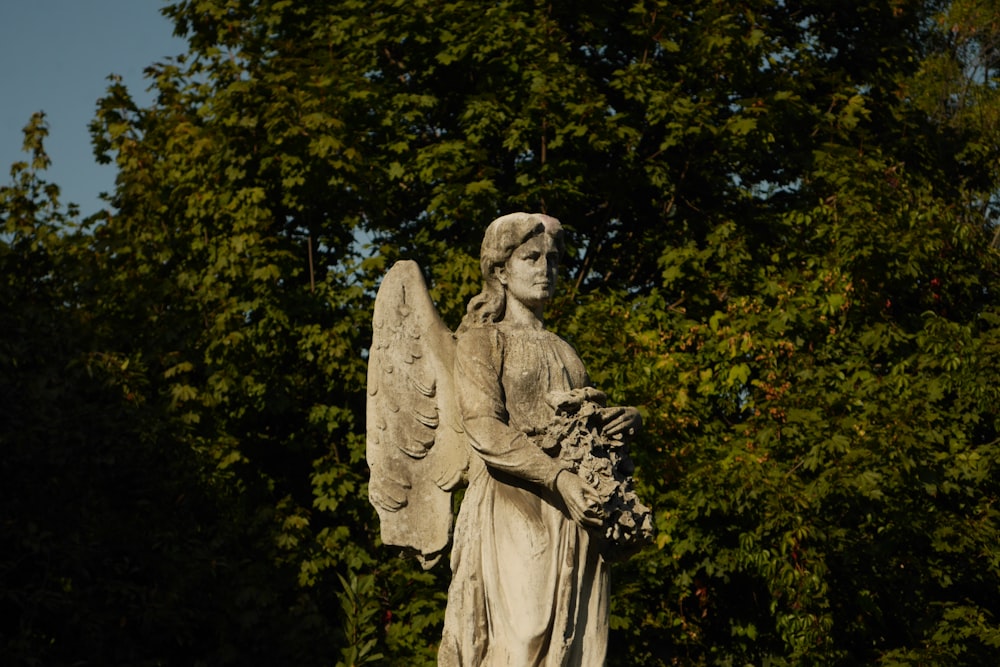 a statue of an angel holding a bouquet of flowers