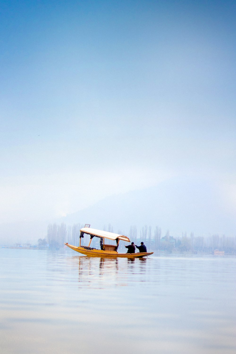 a small boat floating on top of a large body of water