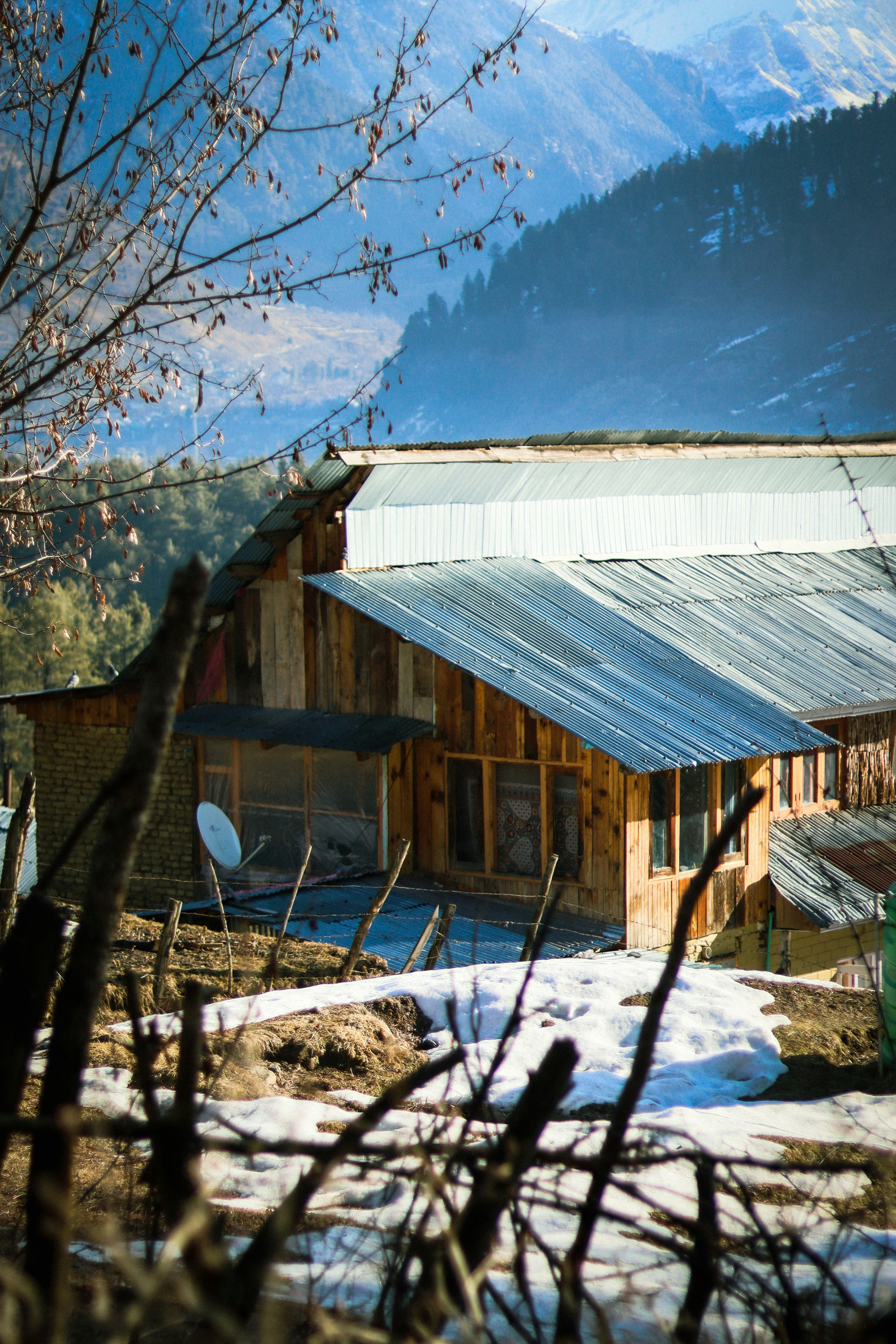 a house with a metal roof in the mountains