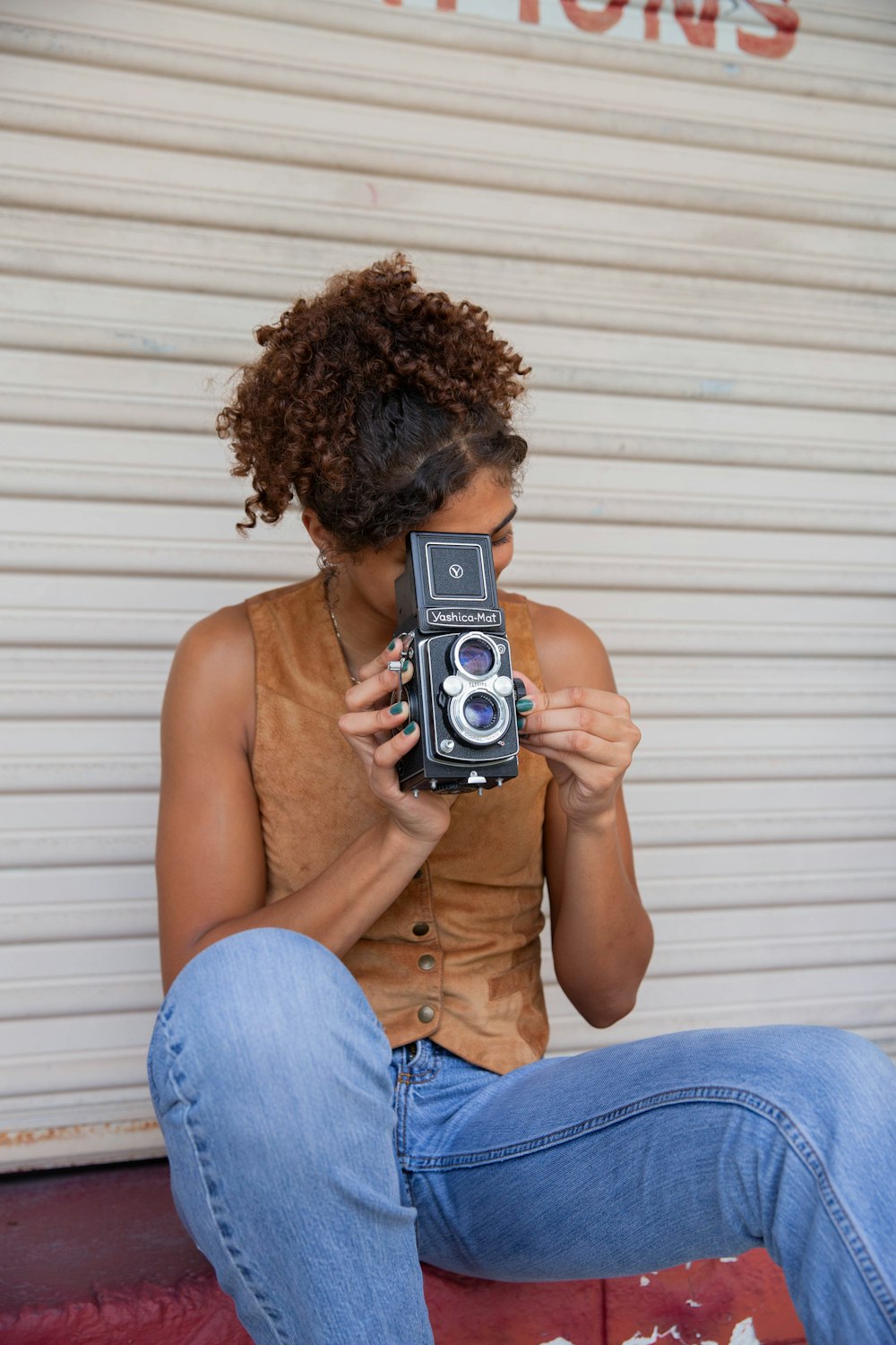 a woman sitting on a step holding a camera