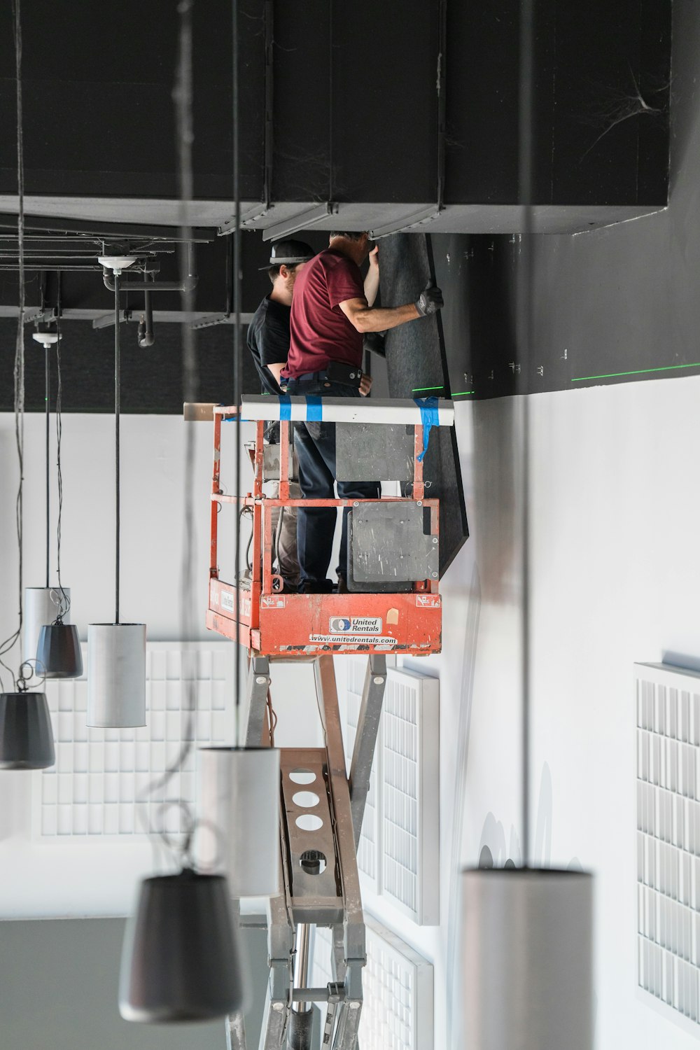 a man standing on a ladder working on a light fixture